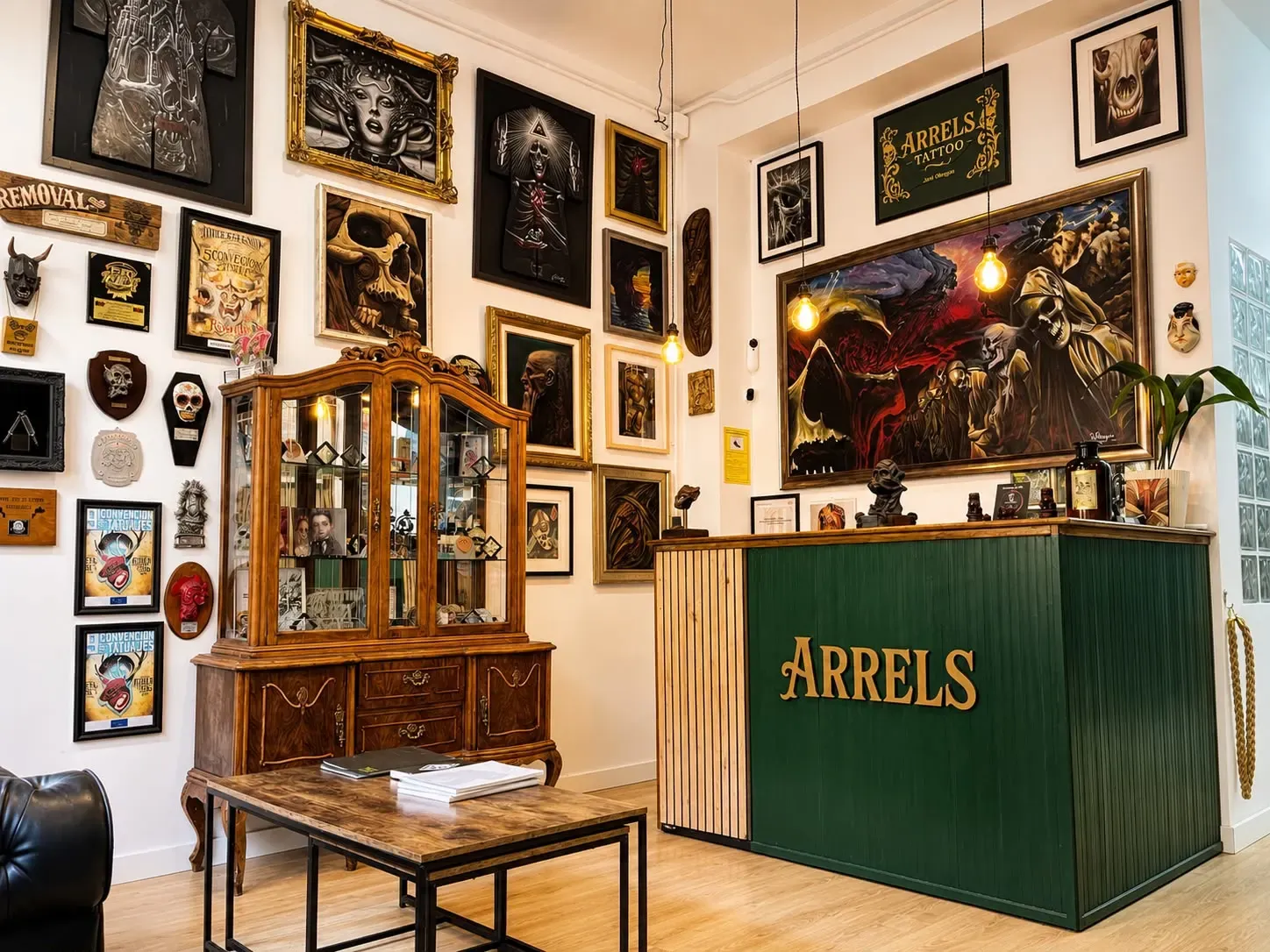 Recepción de Arrels Tattoo con obras originales y el mostrador del estudio